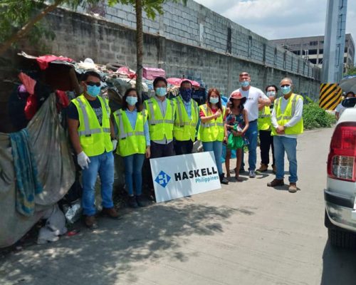 Philippines office employees wearing safety gear pose for a group photo at a construction site